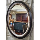 A Silver and Ebonised oval mirror. 48 x 39 cm approx.
