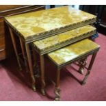 Nest of three gilt metal and onyx tables the cast reeded supports with dolphin terminals, 51cm