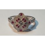 An 18ct gold diamond and ruby cluster ring. Total ruby weight 0.16ct.Total diamond weight 0.39ct.