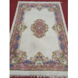 A large Cream ground Carpet with pink and blues. 278 x 183cm approx.