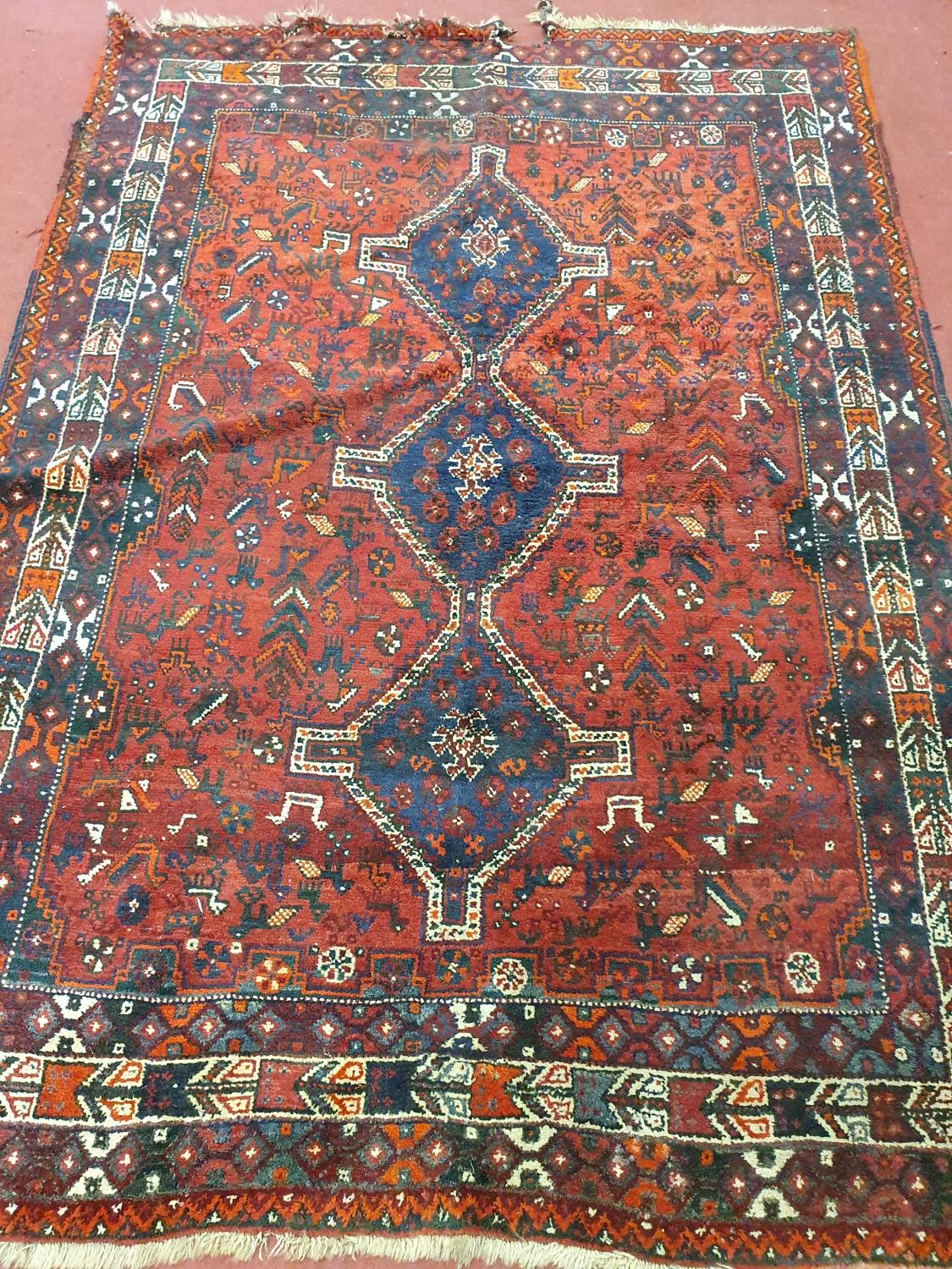 A good burgundy ground Rug. 243 cm x 171 cm approx. (slight damage to one corner).