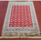 A large Red ground Kashmir Carpet with repeating pattern. 241 x 157 cms.