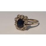 A sapphire and brilliant-cut diamond cluster ring. Stamped 585. Ring size P1/2. 3.2gms.