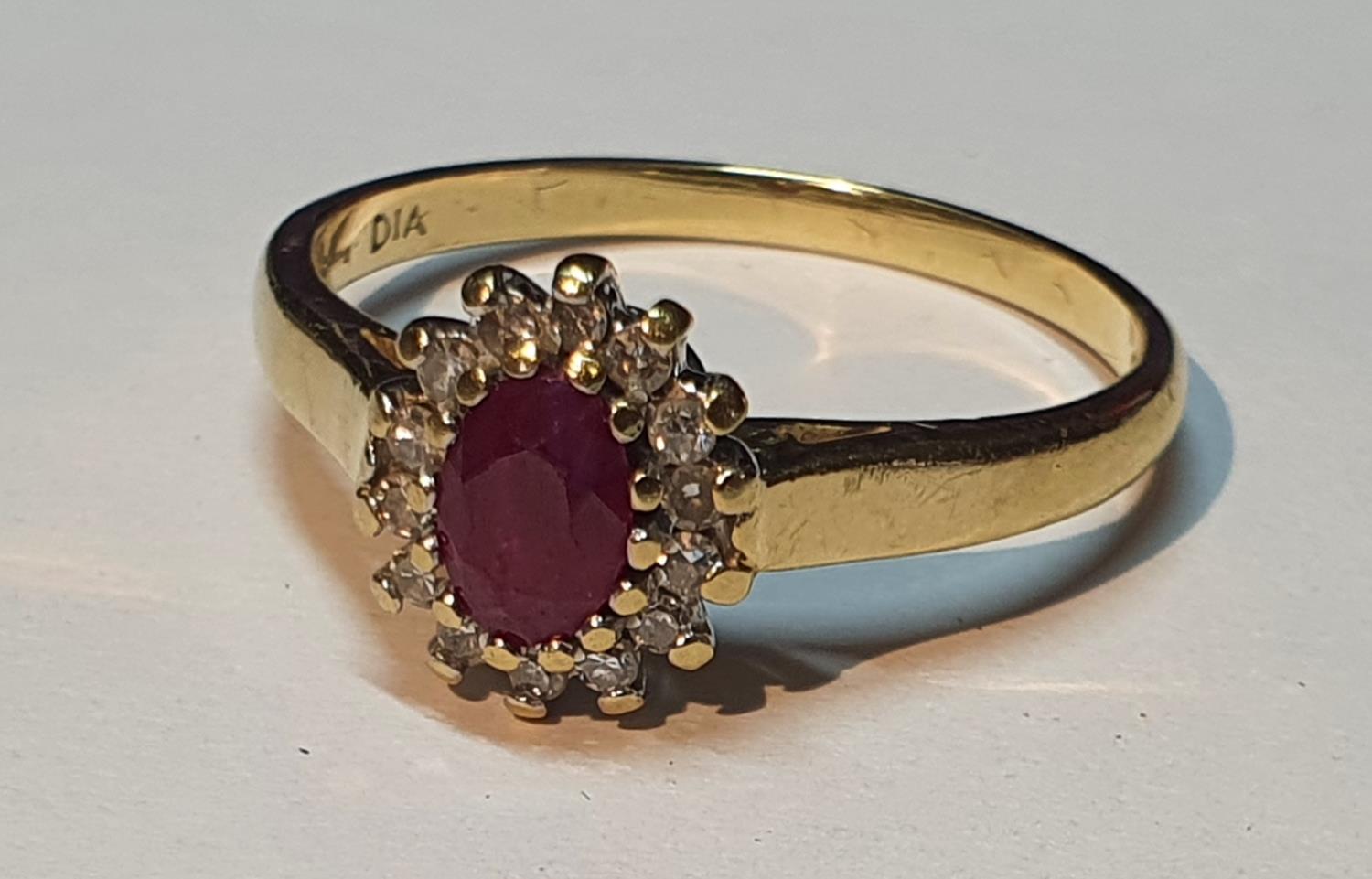 An 18ct gold ruby and diamond cluster ring. Estimated total diamond weight 0.15ct. Hallmarks for