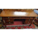 A 19th Century Mahogany kneehole Desk fitted with an arrangement of seven frieze drawers raised on