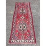 A red ground Persian Runner. 285 x 120 cms approx.