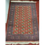 An Iranian Rug with repeating design, multi borders on red/pink ground. 120 x 178 cm approx.