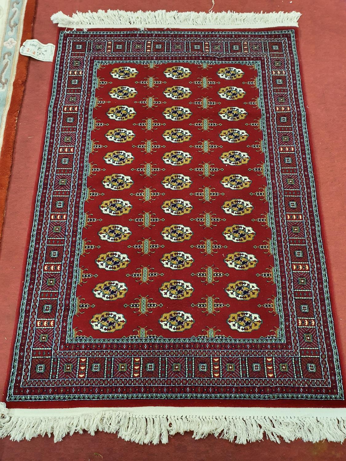 A burgundy deep pile Ground Rug with repeating design and multi borders. 174 x 118 cm approx.