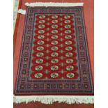 A burgundy deep pile Ground Rug with repeating design and multi borders. 174 x 118 cm approx.