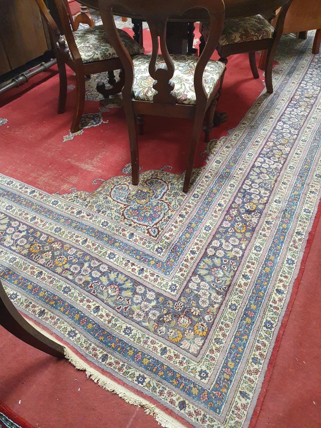 A large Carpet with red ground and multi borders 370 x 280cm approx. (worn).