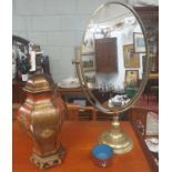 An oval Metal Swing Mirror along with a Table Lamp.