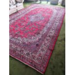 A large rich red ground Persian Surok handwoven Carpet with a central medallion surrounded by a