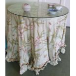 A circular Table with glass top and floral decorated fabric. H73 x Diam.76cm approx along