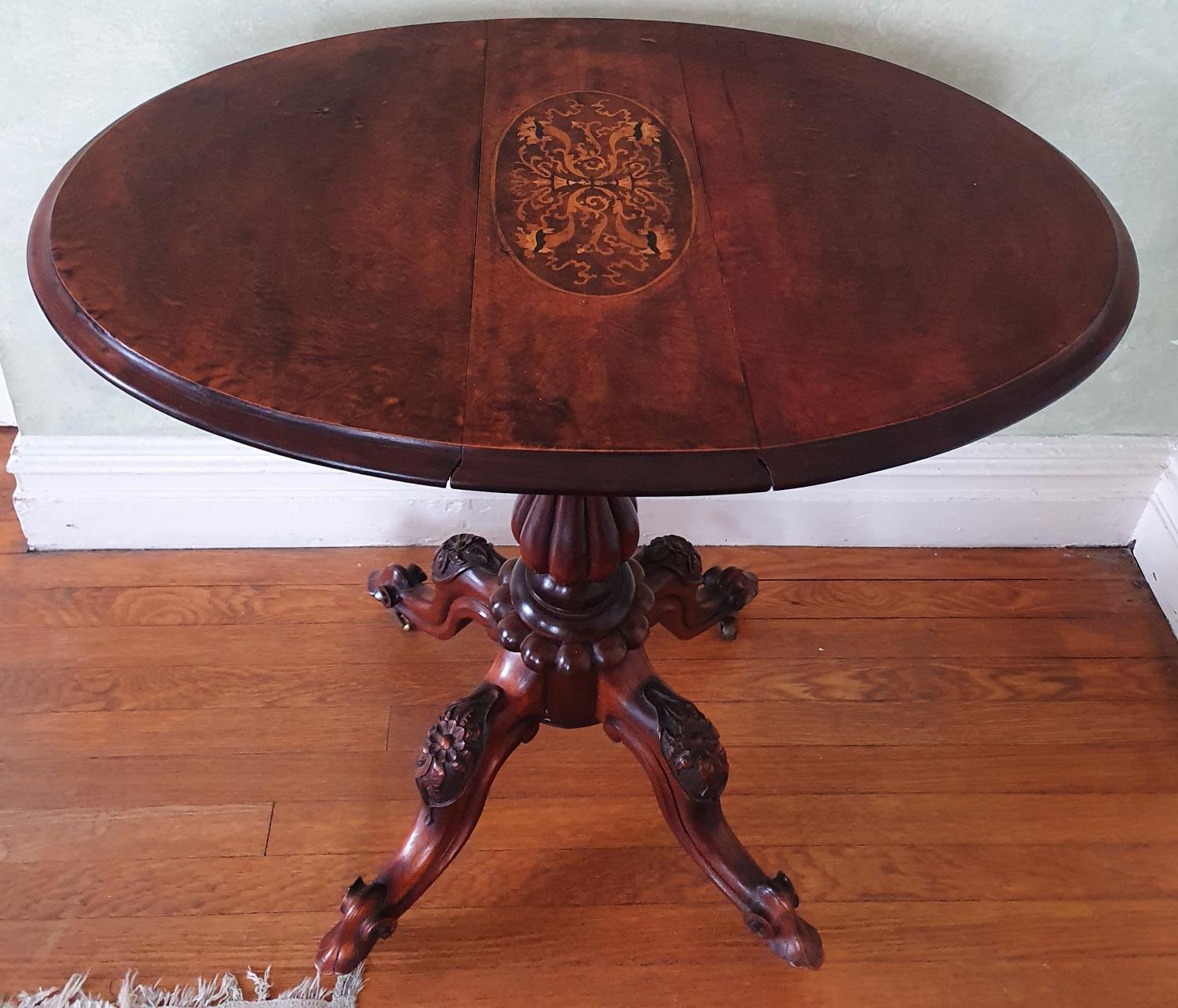 A late 19th early 20th Century oval Walnut Side Table with drop leaves on a turned carved base,