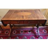 A Regency Mahogany Sofa Table with an oval crossbanded top on twin splayed supports and with brass