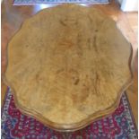A Superb scalloped edge Walnut Centre Table with highly decorated base on brass castors.