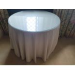A Circular Table with Glass top and fabric base. 88 x 70cm approx.