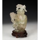 Potiche with flowers. China, XX century. Hand-carved translucent jade on wooden base.