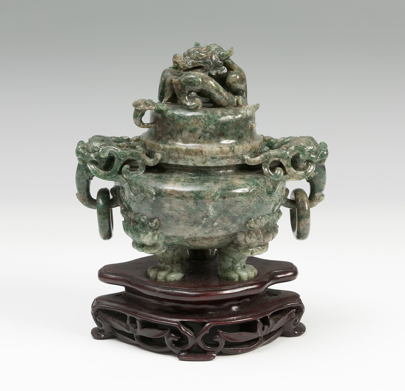 Tibor. China, early 20th century. Nephrite jade. Wooden base. Measurements: 13 x 14 x 9,5 cm; 17