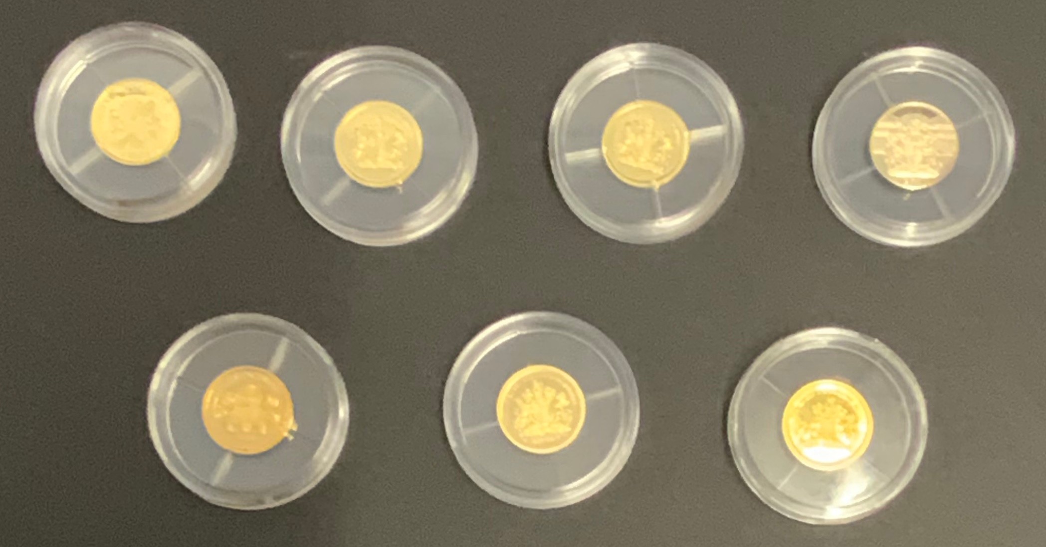 SEVEN MINIATURE GOLD COINS