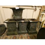 A set of three cast iron garden planter bases, with wreath decoration, 50 cm, together with a cast
