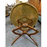 A brass topped table, 90cm diameter 39cm tall, the top with raised border and central floral pattern