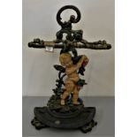 A cast iron and painted umbrella stand, in the form of a cherub.