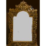 An ornate gilt arched mirror with pierced border, 134 x 85 cm.