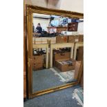 A substantial gilt framed bevel edged wall mirror. 134 x 104 cm