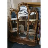 A gilt overmantle mirror 87cm x 76cm The central oval mirror flanked by smaller mirror, the side