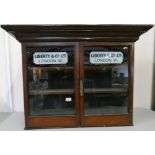 A mahogany glazed two shelf cabinet, with Liberty & Co., London applied decal, 67 x 88 x 26 cm.