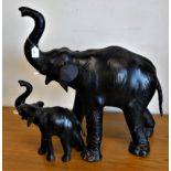 A model elephant, possibly leather covered. 70cm tall, together with a smaller example. (2)