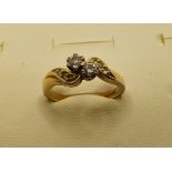 An 18ct gold two stone diamond cross over ring, set with brilliants, diamond set shoulders, 3.5 gms,
