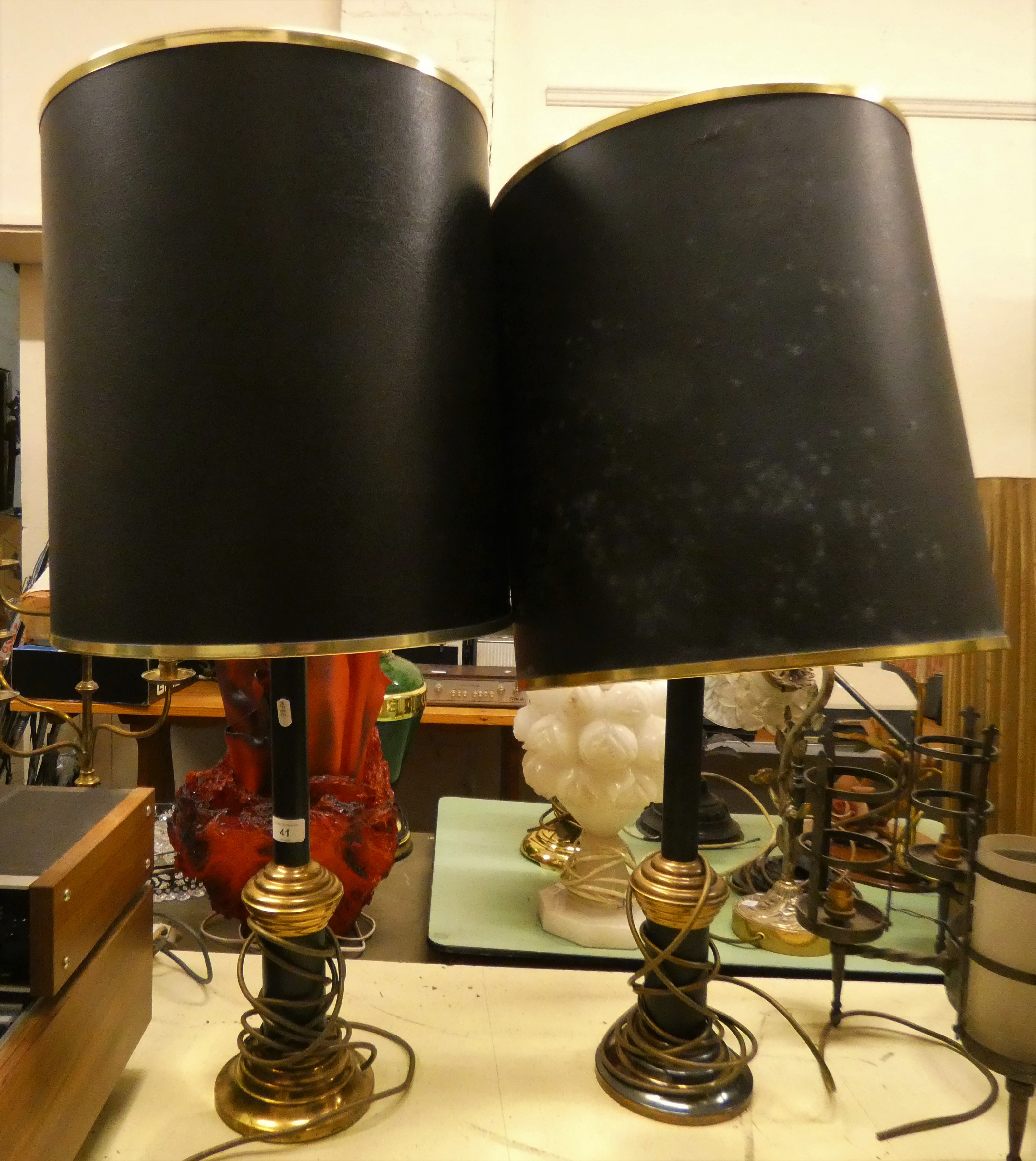 A pair of black and brass table lamps with shades.