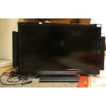A Panasonic TX-L32E30B television with external speaker system, hand set.