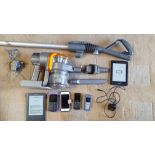A Dyson DC16 hand held vacuum cleaner with accessories, 2 x Amazon Kindles, and 4 x mobile phones.