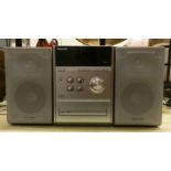 A Panasonic CD stereo system SA PM33 with speakers and a sewing machine