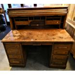 An oak roll top desk in need of repair and restoration.