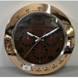 A quartz wall clock in the form of the dial of a Rolex Daytona, diameter 34 cm.