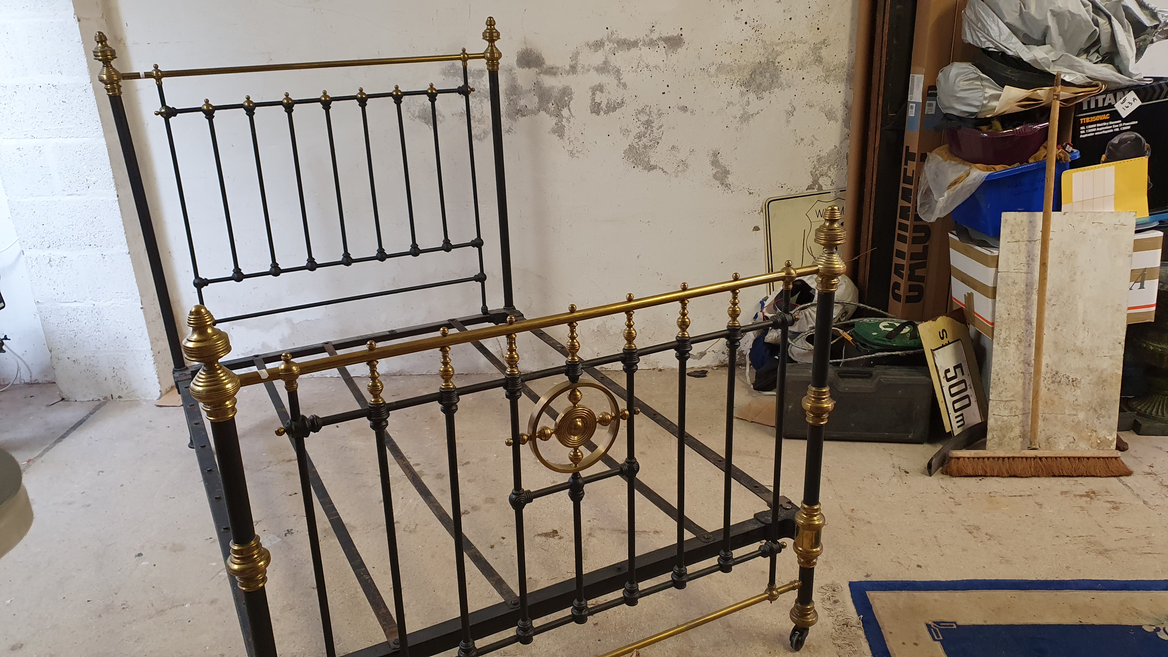 A Victorian cast iron and brass double bed, with castors, one strap missing, 140 cm.