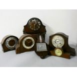 Three oak cased mantle clocks, two mahogany cased mantle clocks, and an oak cased wall barometer.