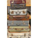 A green canvas covered suitcase and 6 other suitcases (7).