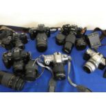 A collection of cameras to include Nikon F65 with lens, Pentax MZ50 with lens, Canon 5000 with lens,