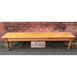 A Highland Railway (HR) pitch pine waiting room bench, raised on turned legs, branded multiple times