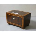 A mohogany inlaid and cross banded tea caddy on raised bobbin feet.