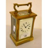 A brass cased manual wind carriage clock with white enamelled dial and Roman numerals, stamped ACG