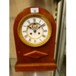 A mahogany cased mantle clock with domed top, white enamelled dial, and Roman numerals. 39cm tall.