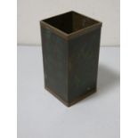 A square oriental metal brush pot, decorated on two sides with character marks to the other two.