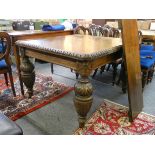 An Edwardian oak wind out dinning table with bulbous carved legs, two extra leaves, 106 x 112 cm