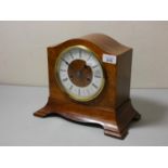 A walnut cased manual wind mantle clock.
